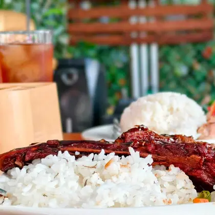 Belly back ribs with rice and mixed vegetables on a white plate